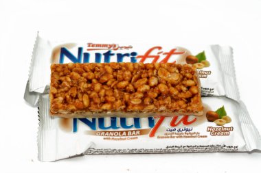 Cairo, Egypt, February 10 2023: Nutrifit granola bar with hazelnut cream, sweet sugary snack, sweetness and aromas of Apple Pie, selective focus of delicious candy of mixed granola and hazelnut