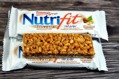 Cairo, Egypt, February 10 2023: Nutrifit granola bar with hazelnut cream, sweet sugary snack, sweetness and aromas of Apple Pie, selective focus of delicious candy of mixed granola and hazelnut
