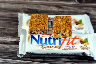 Cairo, Egypt, February 10 2023: Nutrifit granola bar with hazelnut cream, sweet sugary snack, sweetness and aromas of Apple Pie, selective focus of delicious candy of mixed granola and hazelnut