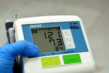 Cairo, Egypt, February 11 2023: ALP K2 Intelligent accurate and easy to use digital blood pressure and pulse monitor, Japanese made showing normal range of blood pressure 121 on 73 mmHg and 84 pulse
