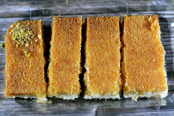 コナファはナッツで覆われ ホイップクリームを詰め 蜂蜜砂糖シロップで浸した ラマダーン月のデザートとしてナッツと東トルコとエジプトのクナファ 選択的な焦点 — ストック写真