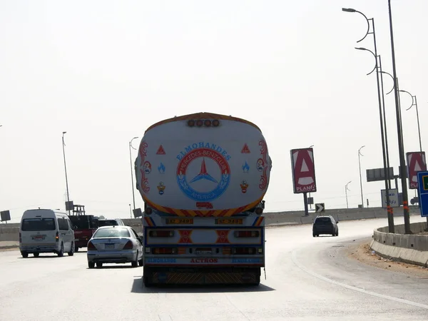 stock image Giza, Egypt, March 9 2023: A big truck with a container tank with petroleum products, a lorry on the highway with a container on it delivering the products for industrial usage, selective focus