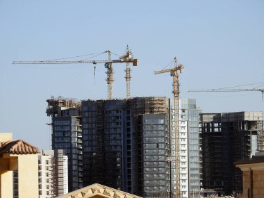 Giza, Mısır, 10 Mart 2023: Zed şehri Orascom İnşaat şirketi, binalar, Sheikh Zayed şehrindeki yeni apartmanların yüksek binaları vinçleri ve gökdelenleri olan, seçici odaklı