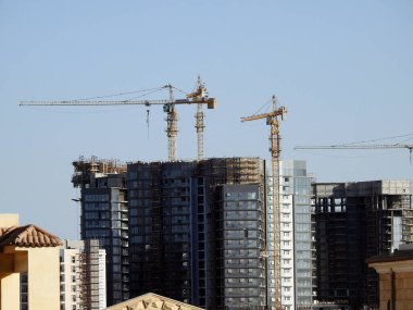 Giza, Mısır, 10 Mart 2023: Zed şehri Orascom İnşaat şirketi, binalar, Sheikh Zayed şehrindeki yeni apartmanların yüksek binaları vinçleri ve gökdelenleri olan, seçici odaklı