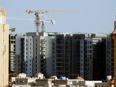 Giza, Mısır, 10 Mart 2023: Zed şehri Orascom İnşaat şirketi, binalar, Sheikh Zayed şehrindeki yeni apartmanların yüksek binaları vinçleri ve gökdelenleri olan, seçici odaklı