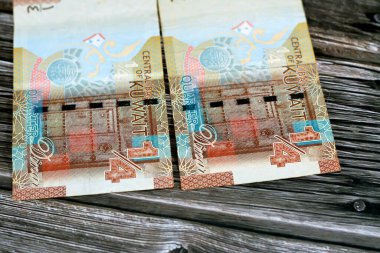 Kuveyt 'in çeyrek dinar kahverengi kağıt para banknotu nakit para banknotu banknotunun ters tarafında geleneksel bir tahta Kuveyt kapısı ve ilk Kuveyt madeni para sayısı 2014 tahtadan arka planda izole edildi.