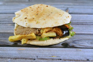 Patates kızartması, fasulye püresi, kızarmış patlıcan, mısır falafel yeşil burger, haşlanmış yumurta ve tahini karışımı Shami düz ekmeği, geleneksel bir Mısır dinamit sandviçi.