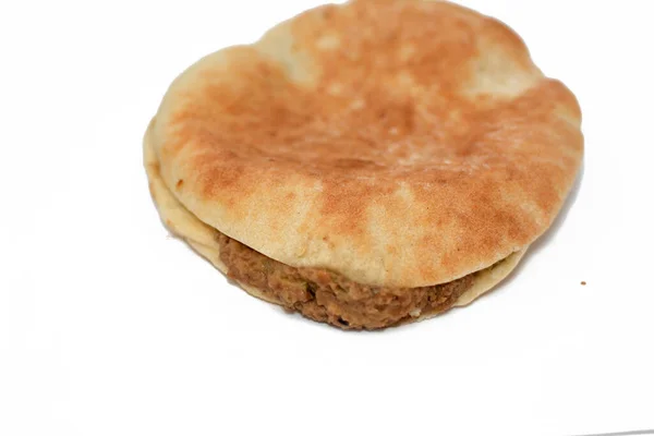 混合了油的蚕豆 芝麻酱 胡椒粉 沙米叙利亚皮塔式面包中的香料 从白色背景中分离出来的传统流行的埃及豆三明治的精选焦点 — 图库照片