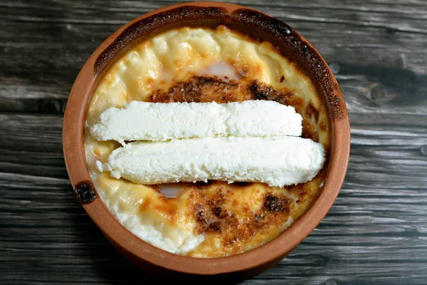 stock image Rice pudding pottery casserole topped with milk cream, rice, corn flour, sugar, water or milk and other ingredients such as cinnamon, vanilla, called Stla, Sholezard, moghli baked