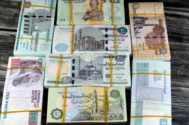 1 LE, 5, 10, 20 EGP ve 50 piaster değerlerinde lastik bantlarla bir araya getirilmiş Mısır para birimi nakit banknotları yığını, 1, 5, 10, 20 Pound