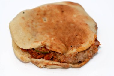 İskenderiye Baharatlı Mısır fasulyesi dilimlenmiş biber, baharat, yağ ve tahini ile geleneksel popüler Mısır fasulye sandviçlerinin seçici odak noktası olan Düz Shami Suriye ekmeği