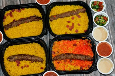 Arabic cuisine traditional food beef  Kofta, kebab and tarb kofta shish which is minced meat with Basmati rice and raisins, oriental grilled barbecued meat food with long yellow rice, selective focus