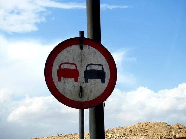 A side road board traffic sign to prohibit passing, no passing zone, no overtaking, do not pass vehicle zone, dangerous driving zone in Giza city in Egypt, selective focus