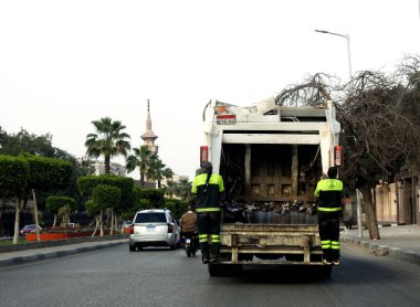 Kahire, Mısır, 23 Mart 2023: çevresel temizlik için çöp bidonlarından çöp toplamak için çöp toplayan büyük bir mobil araç, ağır bir kamyonda atık toplayan belediye çalışanları.