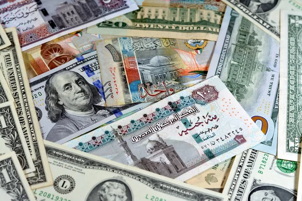 Egyptian pounds currency with American USA dollars cash money banknotes of different values and Kuwait dinars bills, Kuwaiti money, Egyptian pound EGP LE and American currency exchange rate concept