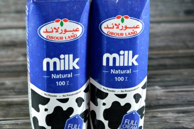 Kahire, Mısır, 16 Mart 2023: Obour Land tam kremalı inek sütü şişesi. 1 litre litrelik koruyucu madde ve toz yok, seçici odak noktası ahşap arka planda.