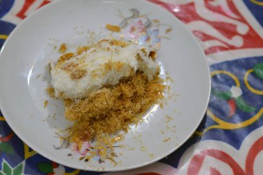 Krem şanti, kuru üzüm, ceviz, hindistan cevizi ve krema ve taze mango katmanıyla doldurulmuş ve ballı şeker şurubuyla ıslanmış, Doğu Türkçe ve Mısır 'da mangalı kunafa