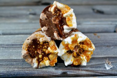 Dondurma, vanilya ve çikolata külahları. Çikolata, karamel sosu ve gevrek bir külahta fındık. Soğuk dondurmayı bisküvinin içinde eritmek, yaz tatili kavramı.