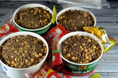 Kahire, Mısır, 28 Mart 2023: El Tahrir Koshary Koshari, pirinç, makarna, spagetti ve mercimek karışımı baharatlı domates sosu, sarımsak sirkesi, kızarmış soğan, humus nohutu