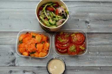 Çeşitli salatalar, domates dilimli Mısır yeşil salatası, salatalık, soğan, patates turşusu, maydanoz, yeşil biberli domates dilimleri ve ahşap üzerine Tahini sosu.