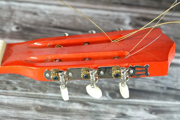 stock image A broken wooden old classic guitar with damaged strings chords, shattered musical instrument, unattached damaged guitar with cut chord and wood, selective focus of non working music instrument