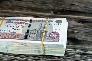 Mısır para yığını ahşap arka planda izole edilmiş 50 EGP LE 50 Mısır sterlini nakit para banknotları Ebu Hurayba Camii 'nin resmi, Edfu tapınağı ve kanatlı böcek, seçici odaklı
