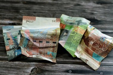 Çökmüş Kuveyt parası, yarısı ve bir KWD Kuveyt dinarı banknotu izole, buruşuk dinar nakit para banknotları, Kuveyt 'te ekonomik enflasyon konsepti, para değeri geçmişi