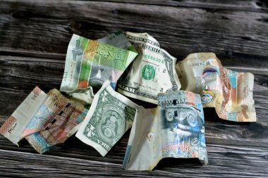 Kırışmış ve buruşmuş Kuveyt yarım, çeyrek ve bir KWD dinar banknot ve bir Amerikan doları nakit para, para enflasyonu ve değer kaybı, düşüş konsepti, iş ve piyasa krizi