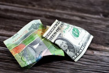Kırışmış ve buruşmuş Kuveyt 'in yarısı KWD dinar banknotu ve 11 Amerikan doları nakit para, para enflasyonu ve değer kaybı, düşüş konsepti, iş ve piyasa krizi, seçici odaklanma