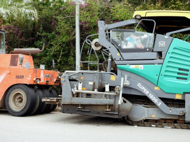 Kahire, Mısır, 8 Nisan 2023: Asfalt kaldırım kamyonları ve sıkıştırıcılar, bir kaldırım taşı (Road Paver finisher, asfalt kaldırım makinesi) asfalt beton döşemek için kullanılan bir yapı malzemesidir.