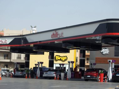 Kahire, Mısır, 18 Nisan 2023: Yeni Kahire 'de benzin ve benzin istasyonu, istasyonun içinde mağazaları ve restoranları olan bir benzin istasyonu ve elektrikli araba ve araçlar için EV şarj ediliyor