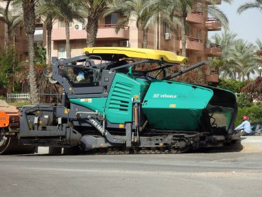 Kahire, Mısır, 18 Nisan 2023: Track asfalt kaldırım kamyonu, bir kaldırım taşı (Road Paver finisher, asfalt kaldırım makinesi) asfalt beton döşemek için kullanılan bir inşaat malzemesidir.