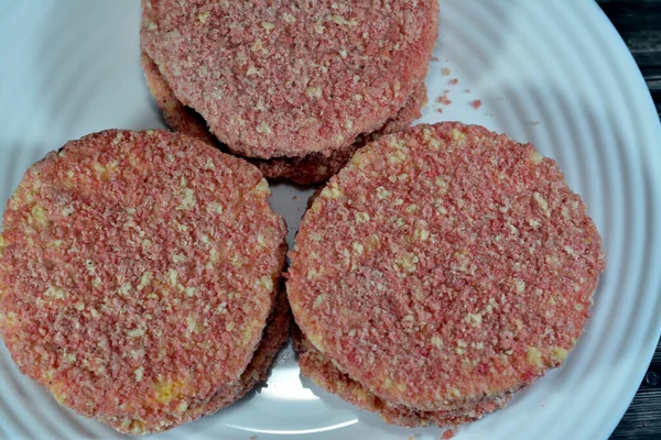 Stock image spicy chicken burger with blend of rich chilly spices and ingredients and breadcrumbs, usually made of with ground chicken, seasoned bread crumbs, grated onion, and garlic ready to be fried in oil