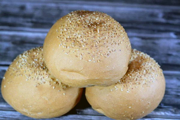 丸い手の大きさのハンバーガーのパン焼きとゴマで覆われ パンは 典型的には小麦粉 バターの生地から作られた風味豊かな充填物で満たされたパンロールの一種です — ストック写真