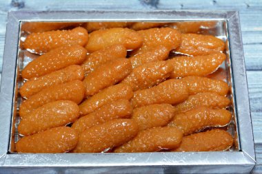 Egyptian Zainab fingers or glazed anise fingers, flour with semolina in the form of fingers that are crunchy on the outside and very soft on the inside and placed in sugar syrup, selective focus clipart