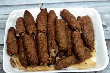 Arabic cuisine traditional food beef  Kofta, kebab and tarb kofta which is minced meat wrapped in lamb fat charcoal grilled and served on flatbread, oriental grilled barbecued meat food