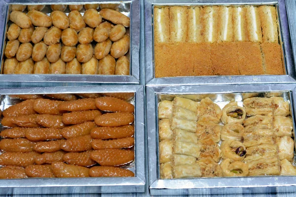 Different types of Eastern sweets of Baklava covered and stuffed with pistachios, Sekerpare (Romoosh el Set), semolina cookies, Zainab fingers or glazed anise fingers, stuffed Knafeh Konafa with cream