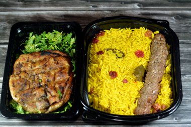 Geleneksel Mısır Hawai 'sinin arka planı, kıyma ve soğanla doldurulmuş pita ve soğanlı biftek Kofta, kebap ve tarb kofta şiş Basmati pilavı ve kuru üzümlü kıyma.