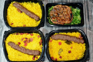 Geleneksel Mısır Hawai 'sinin arka planı, kıyma ve soğanla doldurulmuş pita ve soğanlı biftek Kofta, kebap ve tarb kofta şiş Basmati pilavı ve kuru üzümlü kıyma.