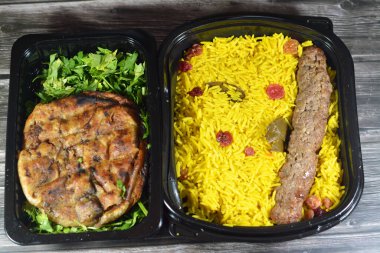 Geleneksel Mısır Hawai 'sinin arka planı, kıyma ve soğanla doldurulmuş pita ve soğanlı biftek Kofta, kebap ve tarb kofta şiş Basmati pilavı ve kuru üzümlü kıyma.