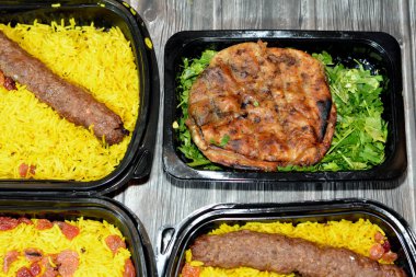 Geleneksel Mısır Hawai 'sinin arka planı, kıyma ve soğanla doldurulmuş pita ve soğanlı biftek Kofta, kebap ve tarb kofta şiş Basmati pilavı ve kuru üzümlü kıyma.