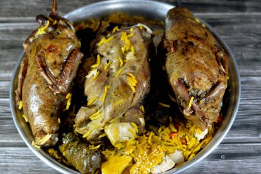 Mısırlı Hamam güvercinleri Mahshi güvercini pirinçle doldurdu ve kuzu inciği fırında pişirildi Basmati pilavı ve sebzelerle doldurulmuş üzüm yaprakları ile iyi pişirildi.