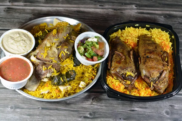 Stock image Egyptian Hamam pigeons Mahshi stuffed squab with rice and a lamb shank cooked well done in a casserole pottery in the oven with Basmati rice and stuffed grape leaves with vegetables, selective focus