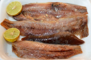 Sıcak tütsülenmiş balık fileto parçaları ve bir tabakta yağ ve limonla hazırlanmış yumuşak bir yumurta. Ringa balığının seçici odak noktası servis edilmeye hazır.