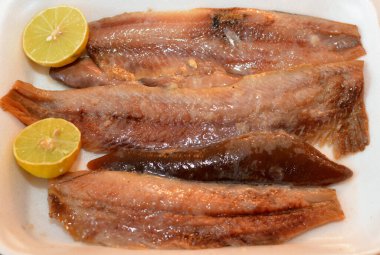 Sıcak tütsülenmiş balık fileto parçaları ve bir tabakta yağ ve limonla hazırlanmış yumuşak bir yumurta. Ringa balığının seçici odak noktası servis edilmeye hazır.