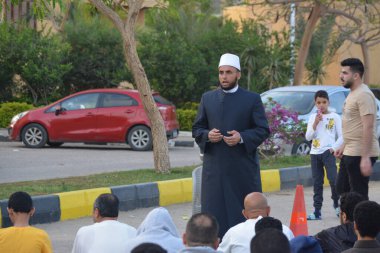Kahire, Mısır, 21 Nisan 2023: Cami vaizi İmam, cami yakınlarındaki açık bir hava sahasında, Ramazan namazı ve kutlamalardan sonraki gün İslami kahvaltı şöleninde Kurban Bayramı 'nı düzenledi.
