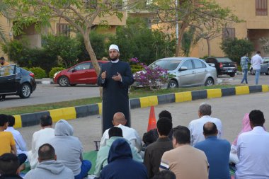 Kahire, Mısır, 21 Nisan 2023: Cami vaizi İmam, cami yakınlarındaki açık bir hava sahasında, Ramazan namazı ve kutlamalardan sonraki gün İslami kahvaltı şöleninde Kurban Bayramı 'nı düzenledi.