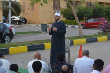 Kahire, Mısır, 21 Nisan 2023: Cami vaizi İmam, cami yakınlarındaki açık bir hava sahasında, Ramazan namazı ve kutlamalardan sonraki gün İslami kahvaltı şöleninde Kurban Bayramı 'nı düzenledi.