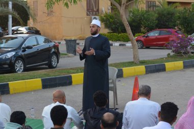 Kahire, Mısır, 21 Nisan 2023: Cami vaizi İmam, cami yakınlarındaki açık bir hava sahasında, Ramazan namazı ve kutlamalardan sonraki gün İslami kahvaltı şöleninde Kurban Bayramı 'nı düzenledi.