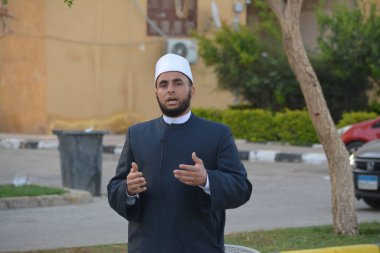 Kahire, Mısır, 21 Nisan 2023: Cami vaizi İmam, cami yakınlarındaki açık bir hava sahasında, Ramazan namazı ve kutlamalardan sonraki gün İslami kahvaltı şöleninde Kurban Bayramı 'nı düzenledi.